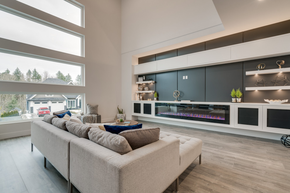 Inspiration for a mid-sized contemporary open concept laminate floor and gray floor family room remodel in Vancouver with white walls, a hanging fireplace, a wood fireplace surround and a media wall