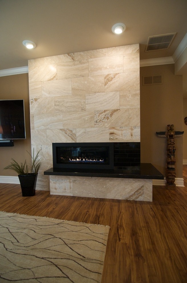 Imagen de sala de estar actual con paredes beige, suelo de madera en tonos medios, chimenea lineal, marco de chimenea de baldosas y/o azulejos y televisor colgado en la pared