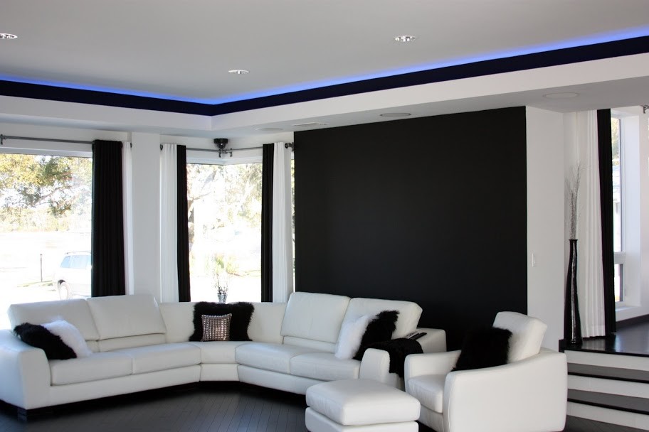 На фото: открытая гостиная комната в современном стиле с домашним баром, белыми стенами, темным паркетным полом, телевизором на стене и черным полом