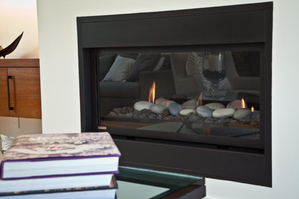 Medium sized contemporary open plan games room in San Francisco with white walls, light hardwood flooring, a ribbon fireplace, a plastered fireplace surround and a wall mounted tv.