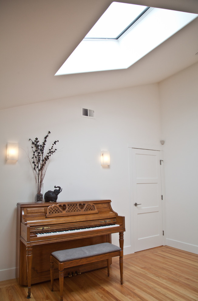 Cette photo montre une salle de séjour tendance de taille moyenne et ouverte avec une salle de musique, un mur blanc, parquet clair, une cheminée ribbon, un manteau de cheminée en plâtre et un téléviseur fixé au mur.