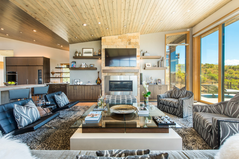 Diseño de sala de estar abierta contemporánea con paredes blancas, chimenea lineal y televisor colgado en la pared