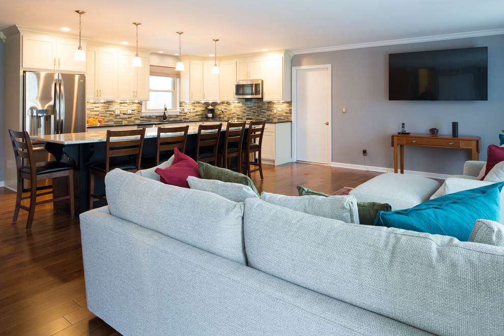 Ejemplo de sala de estar abierta contemporánea de tamaño medio sin chimenea con suelo de madera en tonos medios, paredes grises y televisor colgado en la pared