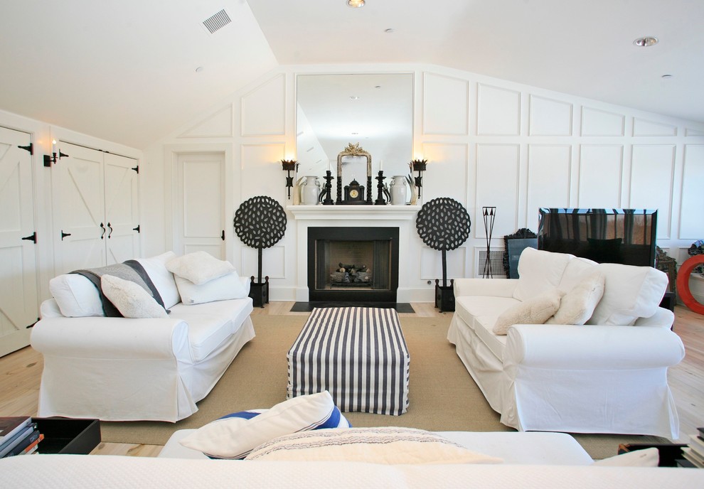 Idée de décoration pour une salle de séjour design avec un mur blanc, parquet clair et une cheminée standard.