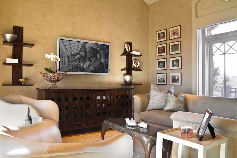 Exemple d'une petite salle de séjour mansardée ou avec mezzanine tendance avec une bibliothèque ou un coin lecture, parquet clair, une cheminée double-face, un téléviseur fixé au mur et un mur beige.