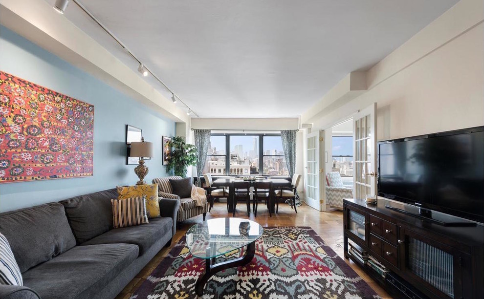 Mittelgroßes, Offenes Klassisches Wohnzimmer ohne Kamin mit bunten Wänden, braunem Holzboden, freistehendem TV und braunem Boden in New York