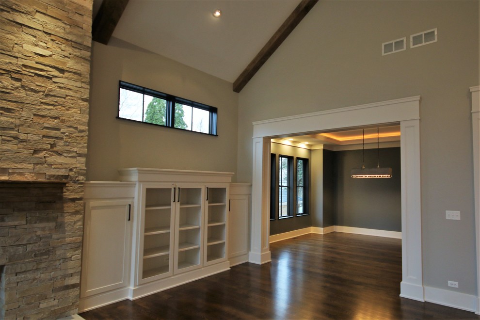 Mid-sized transitional enclosed dark wood floor and brown floor family room photo in Chicago with gray walls, a standard fireplace, a stone fireplace and a wall-mounted tv