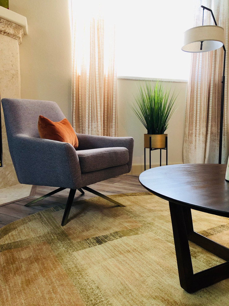 Immagine di un soggiorno minimalista di medie dimensioni e aperto con pareti beige, parquet chiaro e TV autoportante