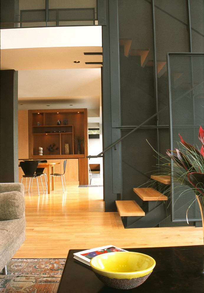 На фото: большая открытая гостиная комната в современном стиле с серыми стенами и светлым паркетным полом