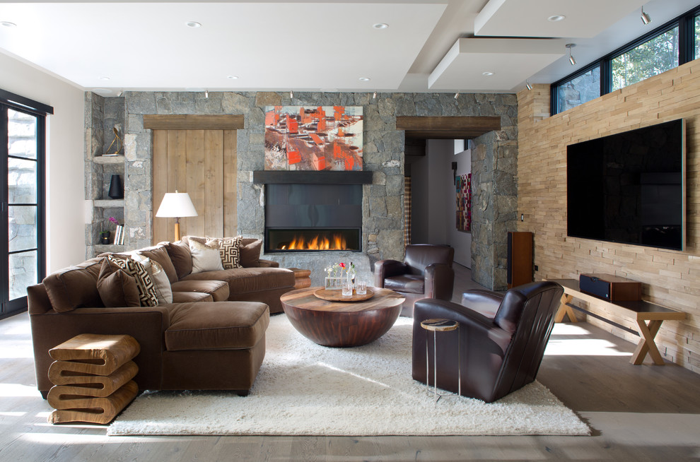 Пример оригинального дизайна: гостиная комната в стиле рустика с светлым паркетным полом, горизонтальным камином, телевизором на стене, бежевым полом и ковром на полу