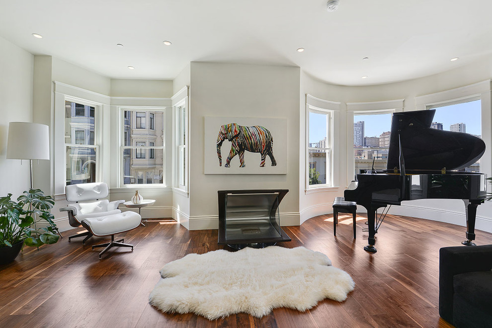 This is an example of a large contemporary open plan games room in San Francisco with a music area, white walls, dark hardwood flooring, a standard fireplace, a metal fireplace surround and brown floors.