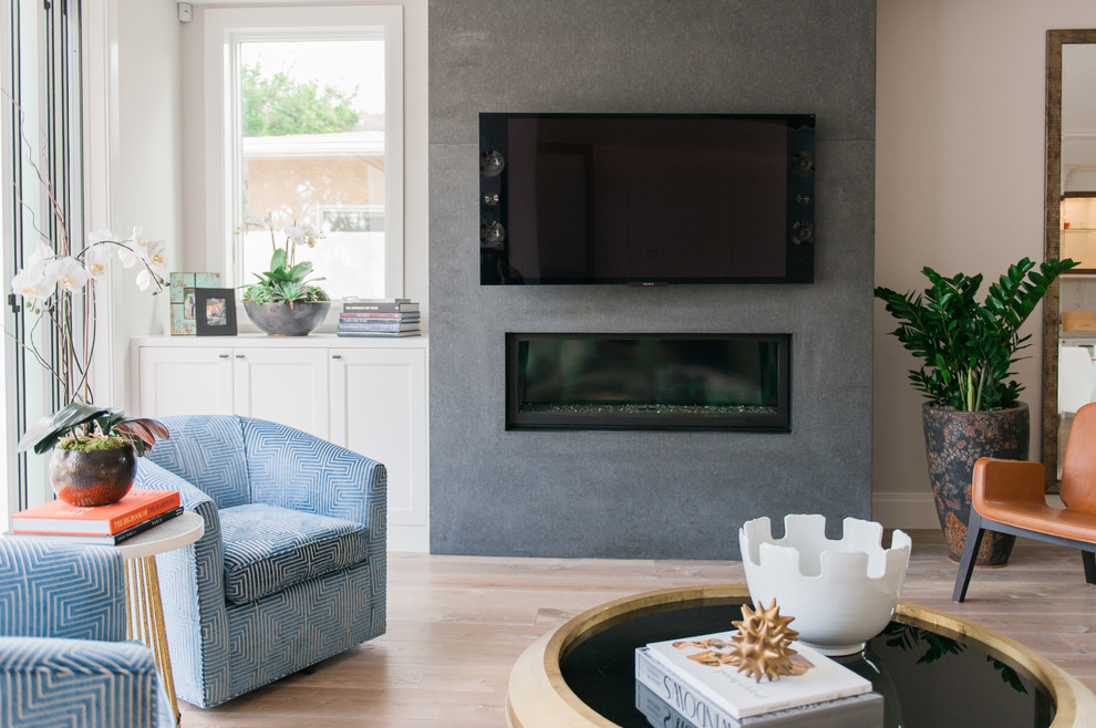 Family room - contemporary open concept light wood floor family room idea in Orange County with beige walls, a stone fireplace and a wall-mounted tv