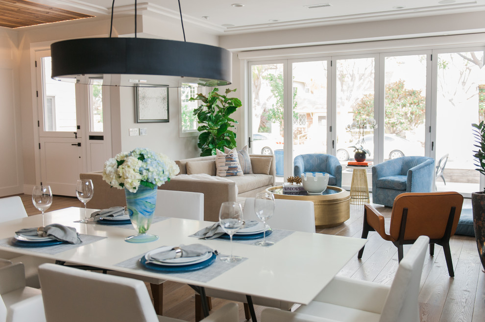 Example of a trendy open concept light wood floor family room design in Orange County with beige walls and a stone fireplace