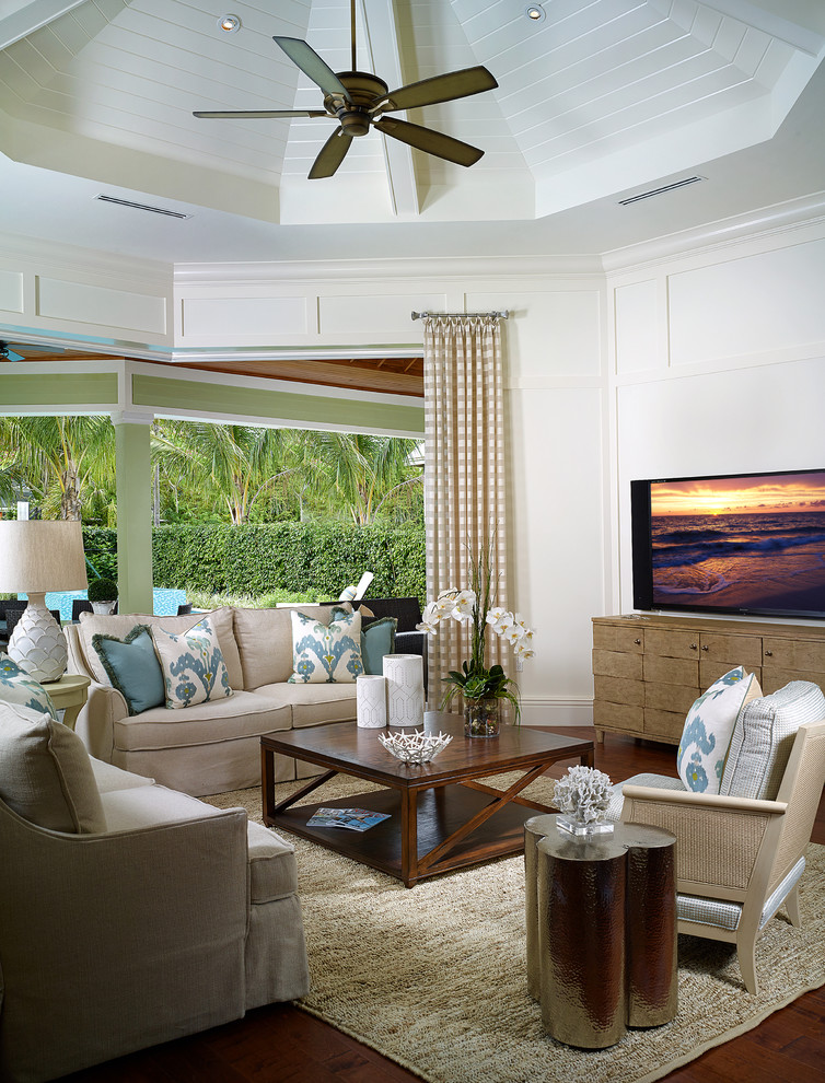 На фото: открытая гостиная комната в морском стиле с белыми стенами, темным паркетным полом и отдельно стоящим телевизором с
