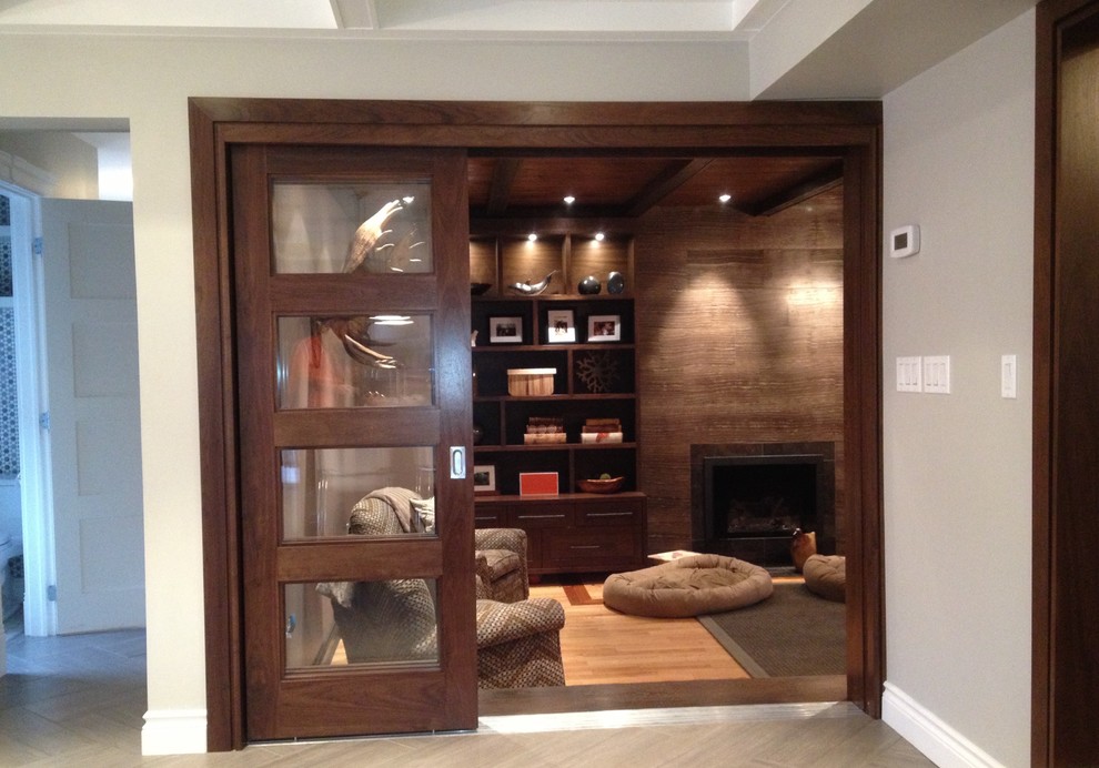 Inspiration for a mid-sized contemporary enclosed light wood floor family room remodel in Toronto with brown walls, a standard fireplace and a wood fireplace surround