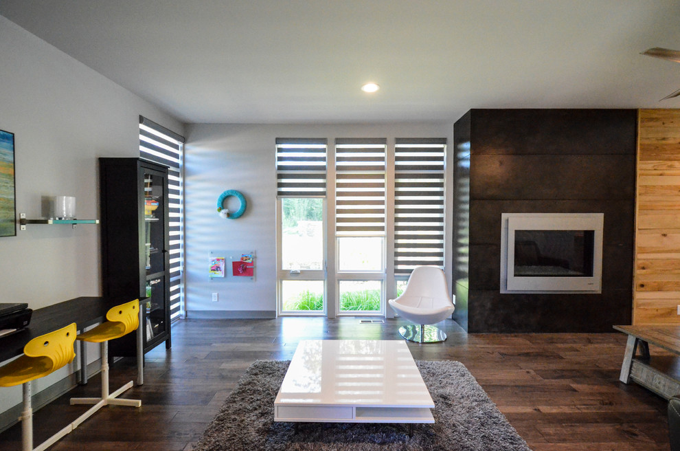Modelo de sala de estar abierta contemporánea de tamaño medio con paredes grises, suelo de madera en tonos medios, todas las chimeneas, marco de chimenea de hormigón y suelo marrón
