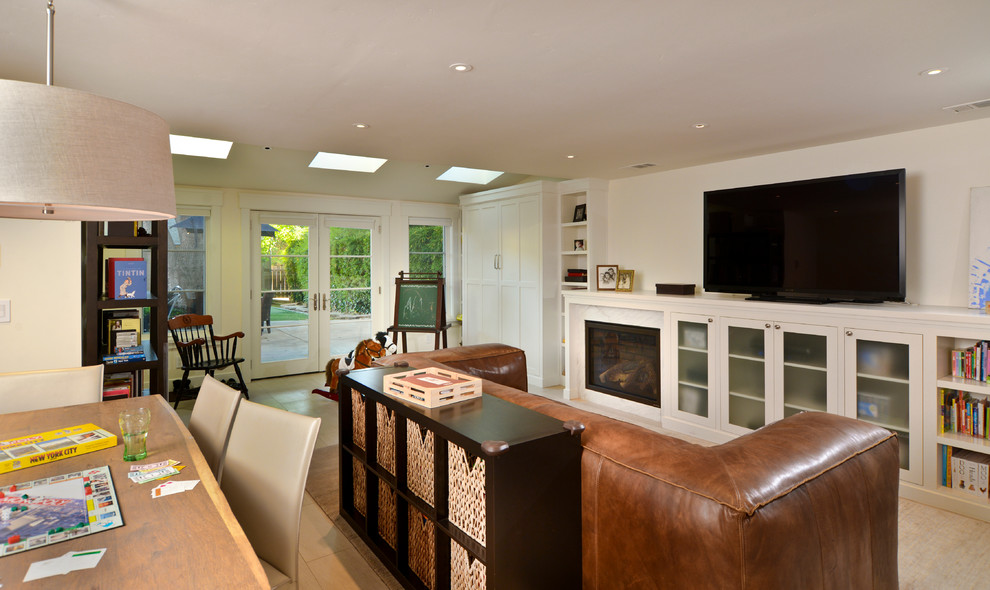 This is an example of a traditional games room in San Francisco with beige walls, a standard fireplace and a freestanding tv.