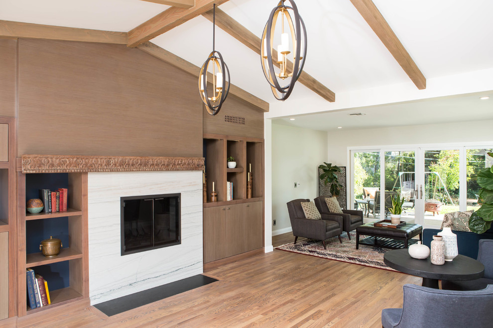 Réalisation d'une salle de séjour design avec un mur bleu, un sol en bois brun, une cheminée standard et un manteau de cheminée en pierre.