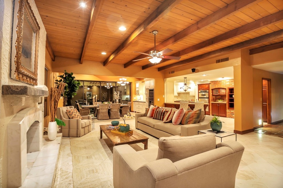 Modelo de sala de estar abierta de estilo americano grande con suelo de baldosas de cerámica, marco de chimenea de piedra y suelo beige