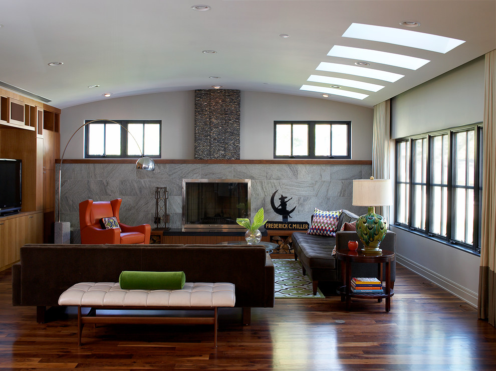 Large traditional open plan games room in Other with a built-in media unit, medium hardwood flooring, grey walls, a standard fireplace and a metal fireplace surround.