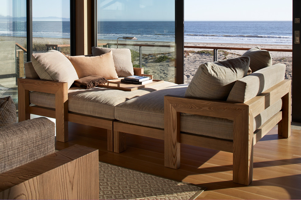 Modelo de sala de estar abierta contemporánea grande sin chimenea con paredes beige y suelo de madera clara