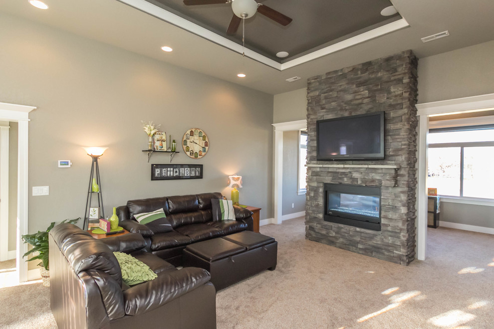 Photo of a medium sized classic open plan games room in Other with grey walls, carpet, a two-sided fireplace, a stone fireplace surround and a wall mounted tv.