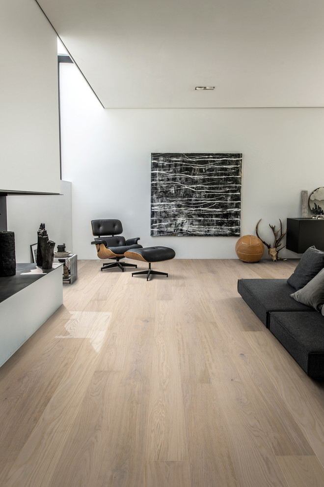 Mittelgroßes Industrial Wohnzimmer ohne Kamin mit beiger Wandfarbe, hellem Holzboden und weißem Boden