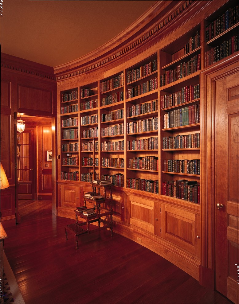 Diseño de sala de estar con biblioteca cerrada clásica de tamaño medio con paredes marrones y suelo de madera en tonos medios