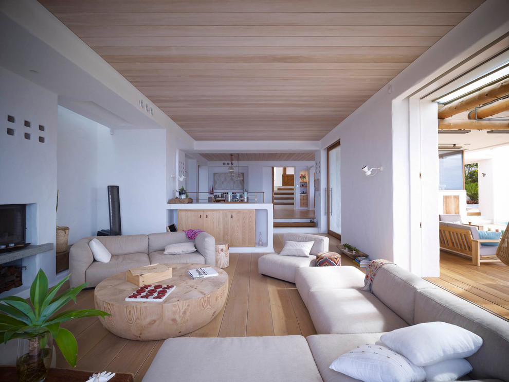 На фото: открытая гостиная комната в морском стиле с белыми стенами и светлым паркетным полом