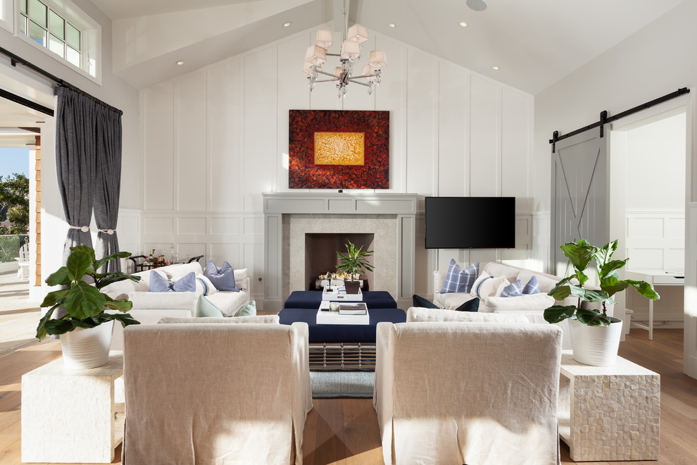На фото: гостиная комната в морском стиле с белыми стенами, светлым паркетным полом, стандартным камином и телевизором на стене