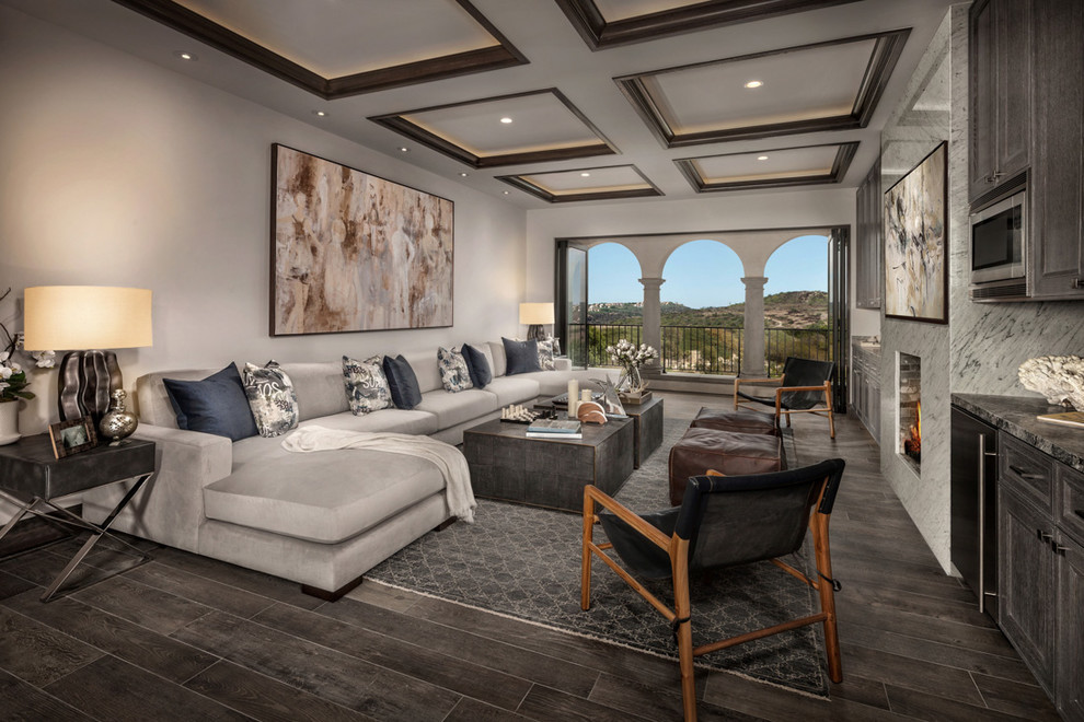 Offenes Mediterranes Wohnzimmer mit Hausbar, weißer Wandfarbe, dunklem Holzboden und braunem Boden in Orange County