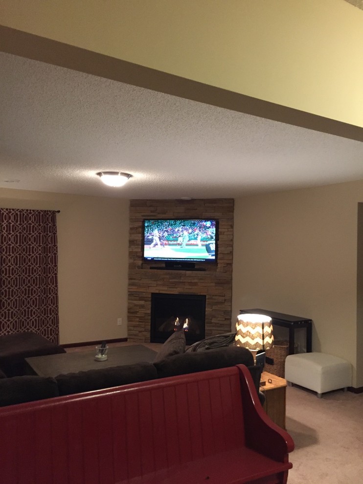На фото: гостиная комната среднего размера в стиле модернизм с бежевыми стенами, ковровым покрытием, угловым камином, фасадом камина из камня и телевизором в углу