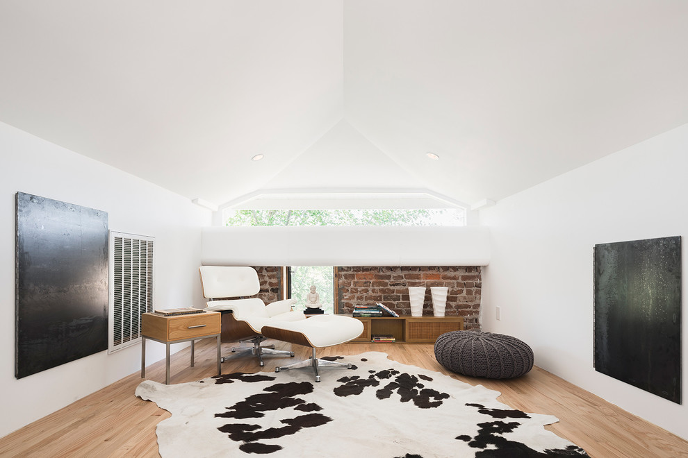 Cette image montre une salle de séjour design avec un mur blanc et un sol en bois brun.