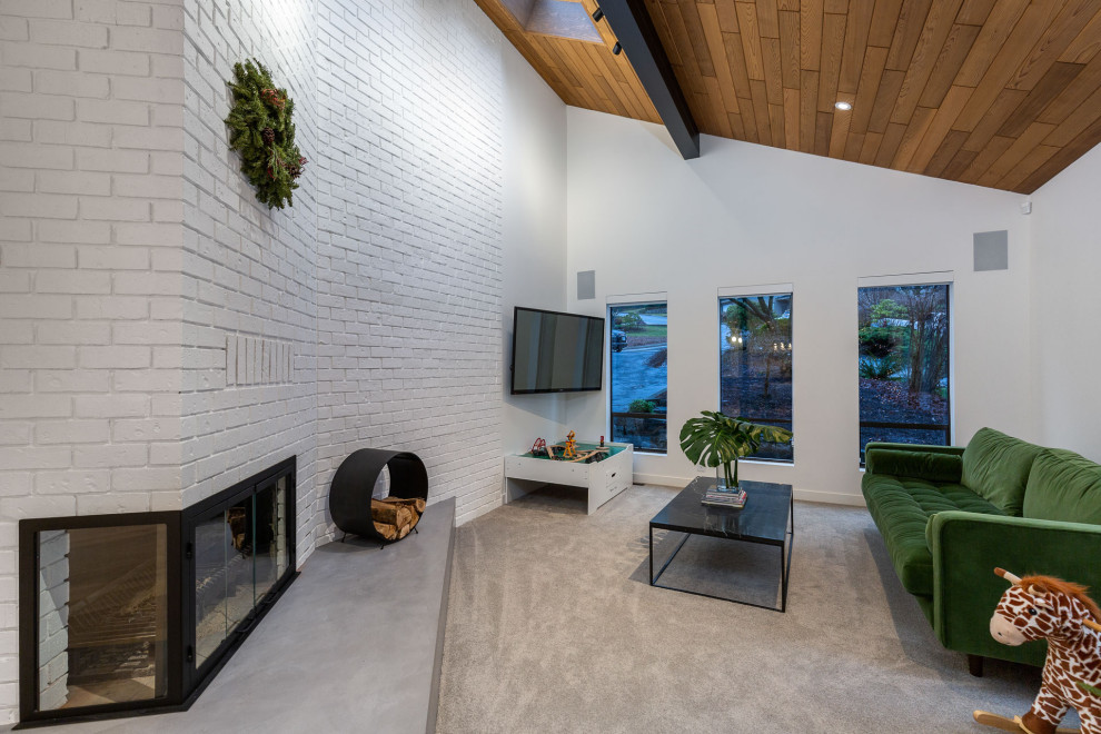 Стильный дизайн: гостиная комната в современном стиле с ковровым покрытием, угловым камином, телевизором на стене и коричневым полом - последний тренд