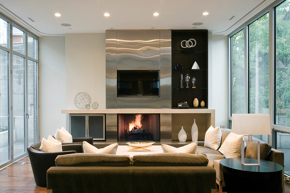 Diseño de sala de estar actual con todas las chimeneas, marco de chimenea de metal y televisor colgado en la pared