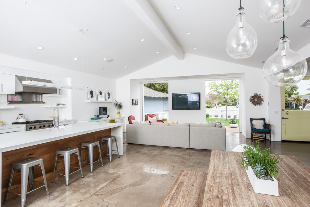 Mid-sized trendy open concept concrete floor and brown floor family room photo in Orange County with white walls, no fireplace and a wall-mounted tv