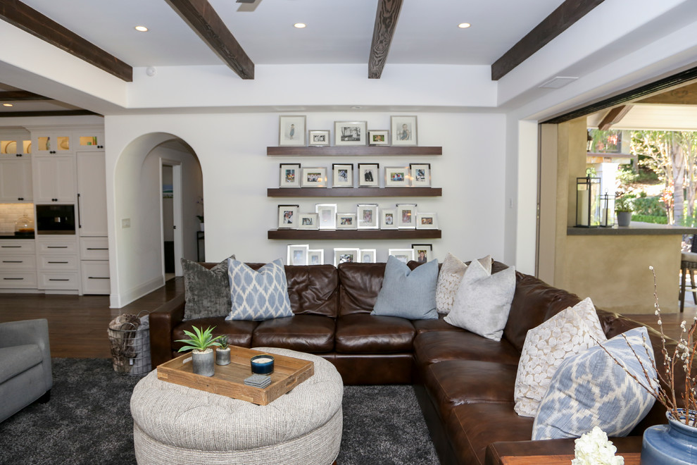 Foto de sala de estar abierta tradicional grande con todas las chimeneas, marco de chimenea de baldosas y/o azulejos, pared multimedia y suelo de madera oscura