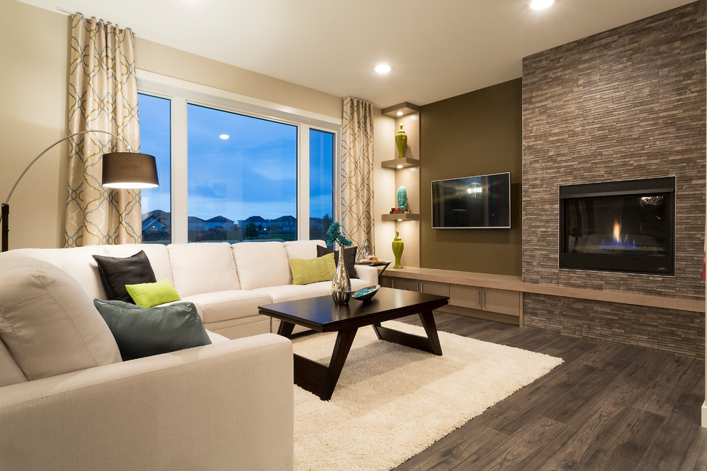 Modernes Wohnzimmer mit beiger Wandfarbe, Gaskamin, gefliester Kaminumrandung, TV-Wand und grauem Boden in Sonstige