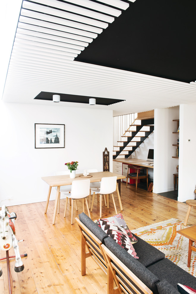 На фото: открытая гостиная комната среднего размера в скандинавском стиле с белыми стенами и светлым паркетным полом