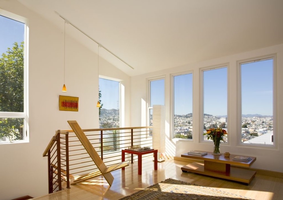 Idée de décoration pour une salle de séjour design avec un mur blanc et parquet clair.