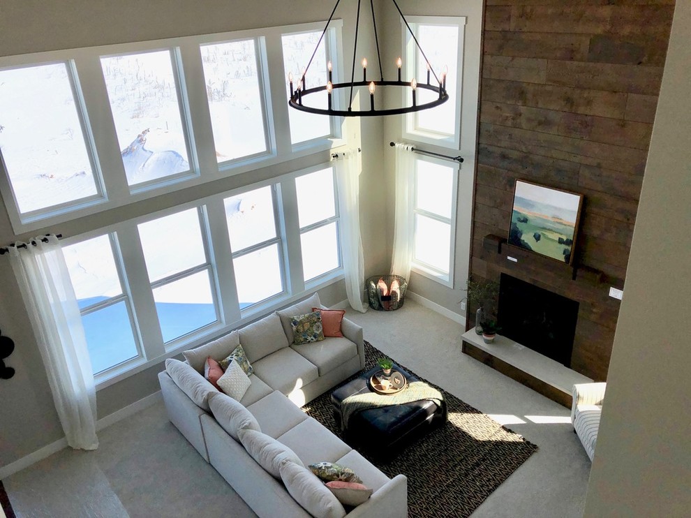 Пример оригинального дизайна: большая открытая гостиная комната в стиле кантри с серыми стенами, ковровым покрытием, стандартным камином, фасадом камина из дерева и бежевым полом