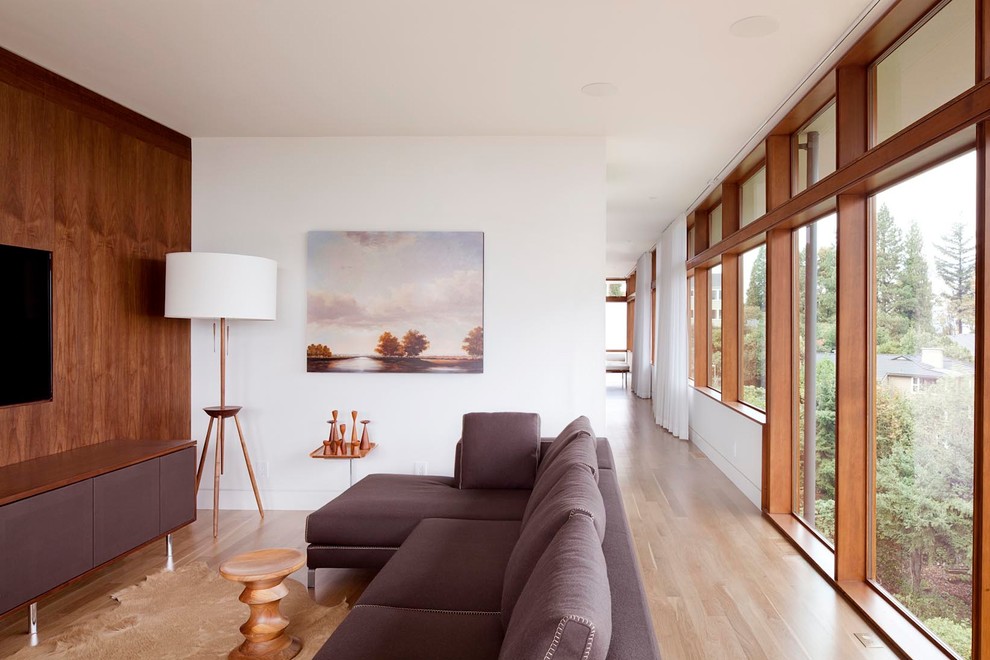 Idee per un soggiorno minimalista di medie dimensioni e stile loft con libreria, pavimento in legno massello medio e TV a parete