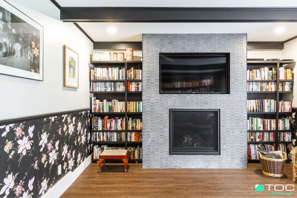 Große, Abgetrennte Shabby-Look Bibliothek mit weißer Wandfarbe, Vinylboden, Kamin, gefliester Kaminumrandung, TV-Wand, braunem Boden, freigelegten Dachbalken und Tapetenwänden in Montreal