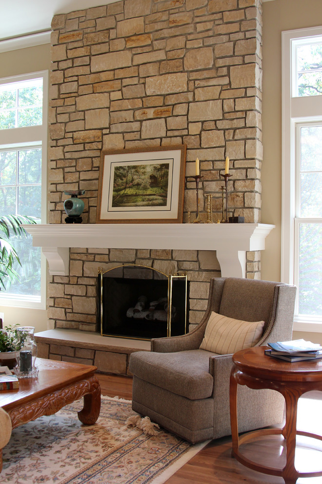 Family room - large transitional enclosed medium tone wood floor family room idea in Milwaukee with beige walls, a standard fireplace and a stone fireplace