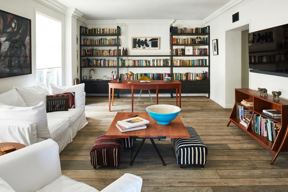 Réalisation d'une salle de séjour tradition de taille moyenne et ouverte avec une bibliothèque ou un coin lecture, un mur blanc, un sol en bois brun, un téléviseur fixé au mur et un sol marron.