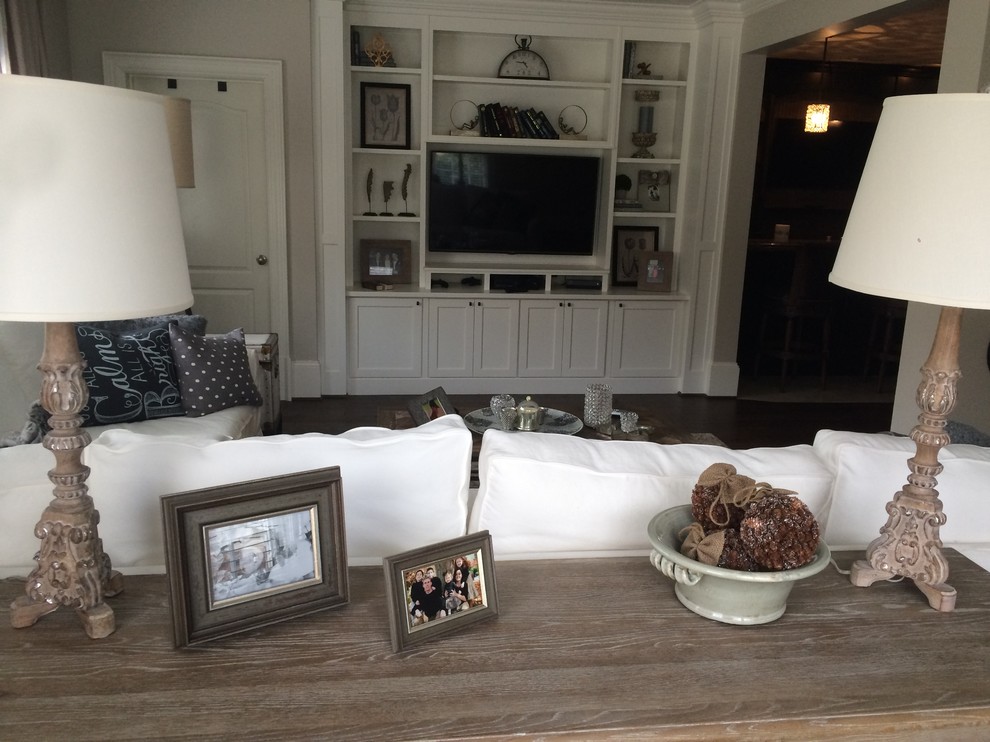 Ejemplo de sala de estar abierta actual pequeña con paredes beige, suelo de madera oscura y pared multimedia