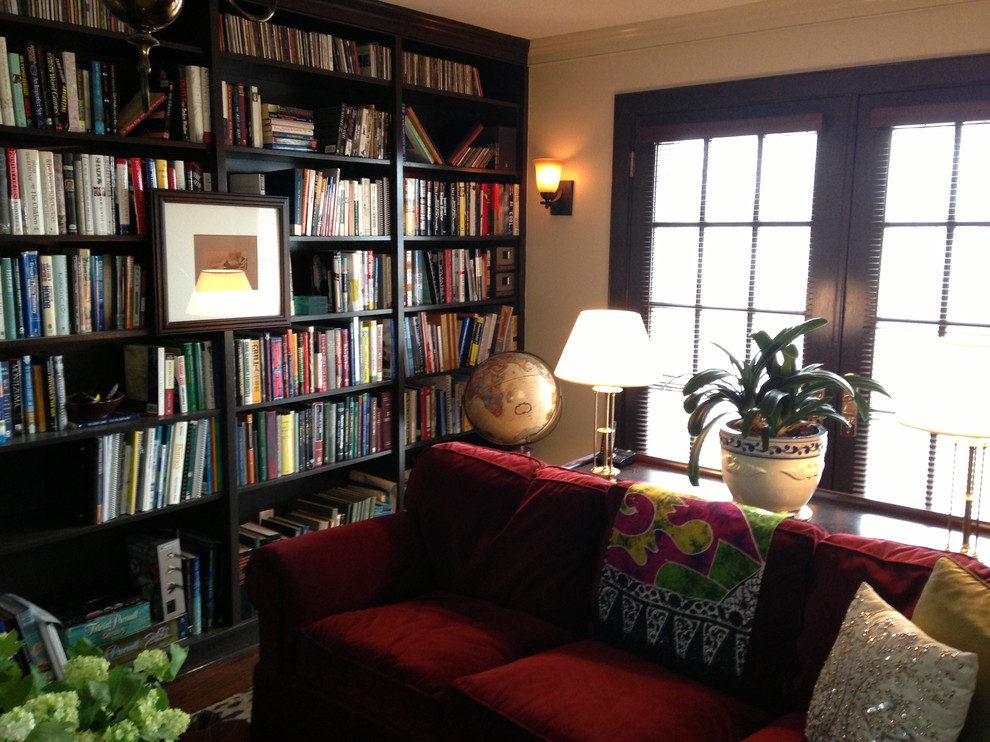 Cette photo montre une salle de séjour éclectique de taille moyenne avec une bibliothèque ou un coin lecture et un mur beige.