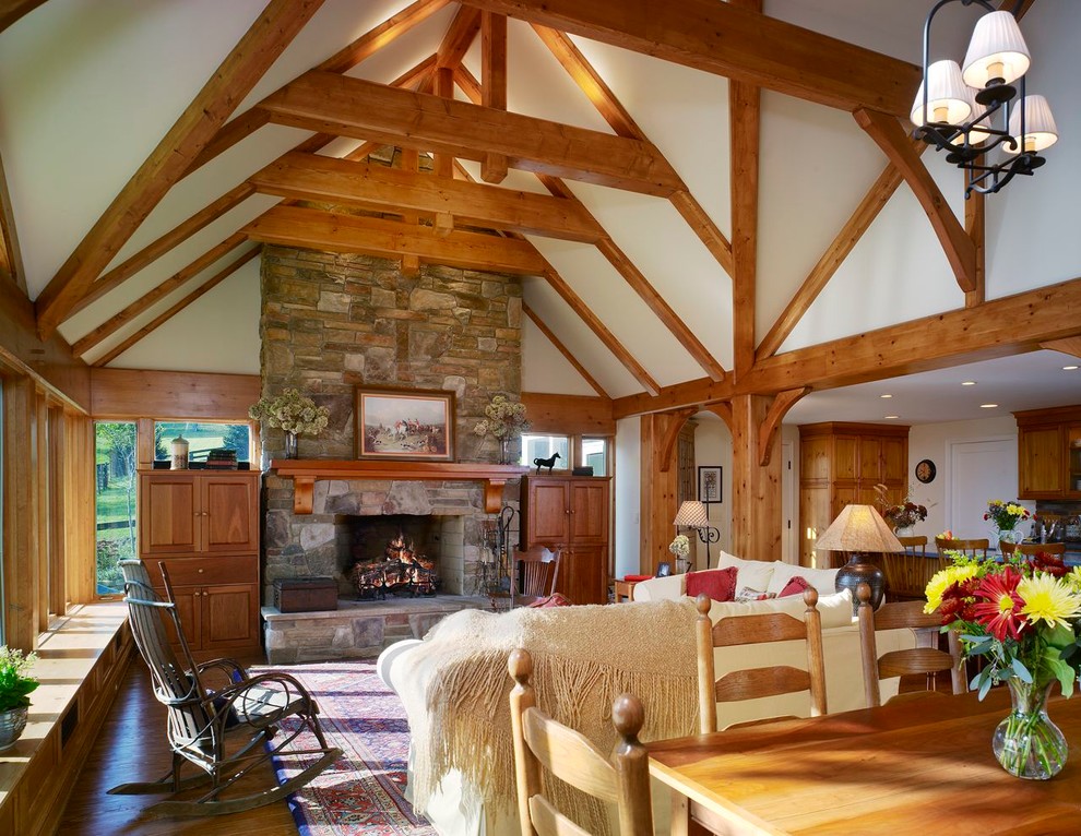 Exemple d'une salle de séjour nature de taille moyenne et ouverte avec un mur beige, parquet clair, une cheminée standard, un manteau de cheminée en pierre et un téléviseur dissimulé.