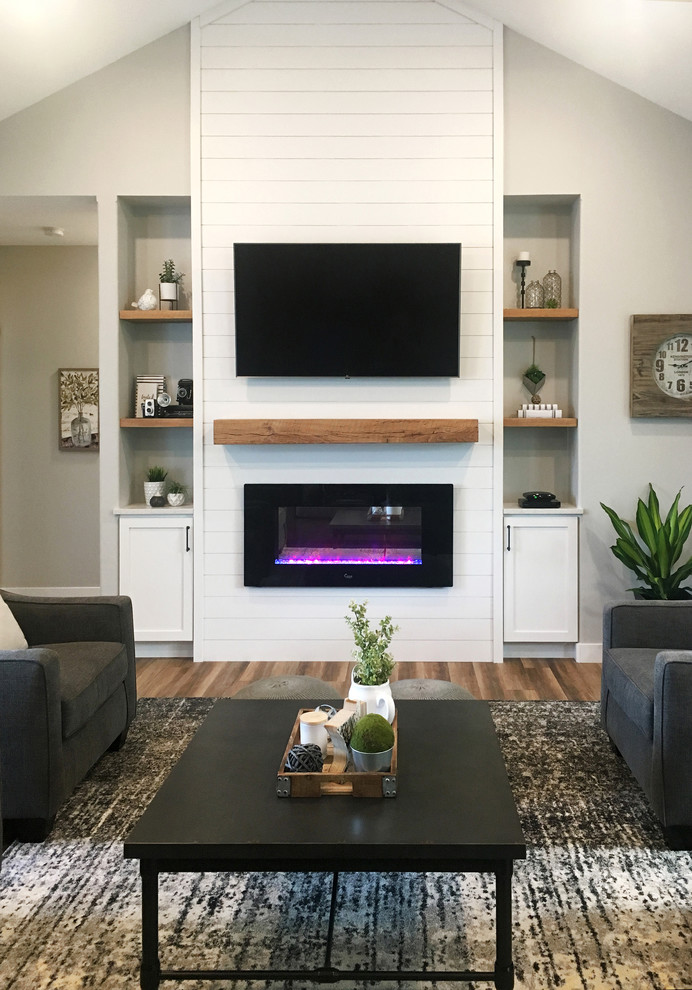 Large farmhouse open plan games room in Other with grey walls, dark hardwood flooring, a ribbon fireplace, a wooden fireplace surround, a wall mounted tv and brown floors.