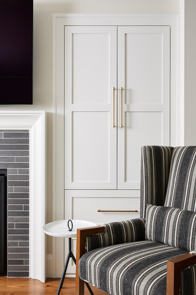 高級な中くらいなトランジショナルスタイルのおしゃれなオープンリビング (ベージュの壁、無垢フローリング、石材の暖炉まわり、壁掛け型テレビ、茶色い床) の写真